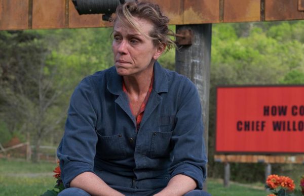 Três cartazes à beira da estrada